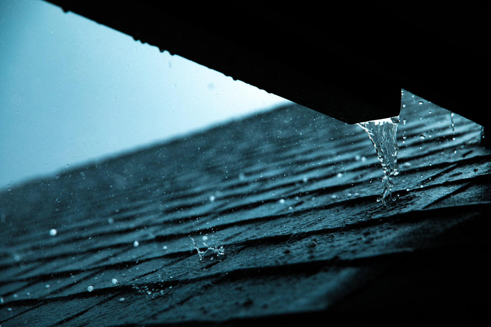 Rainwater running from a roof edge during rainfall